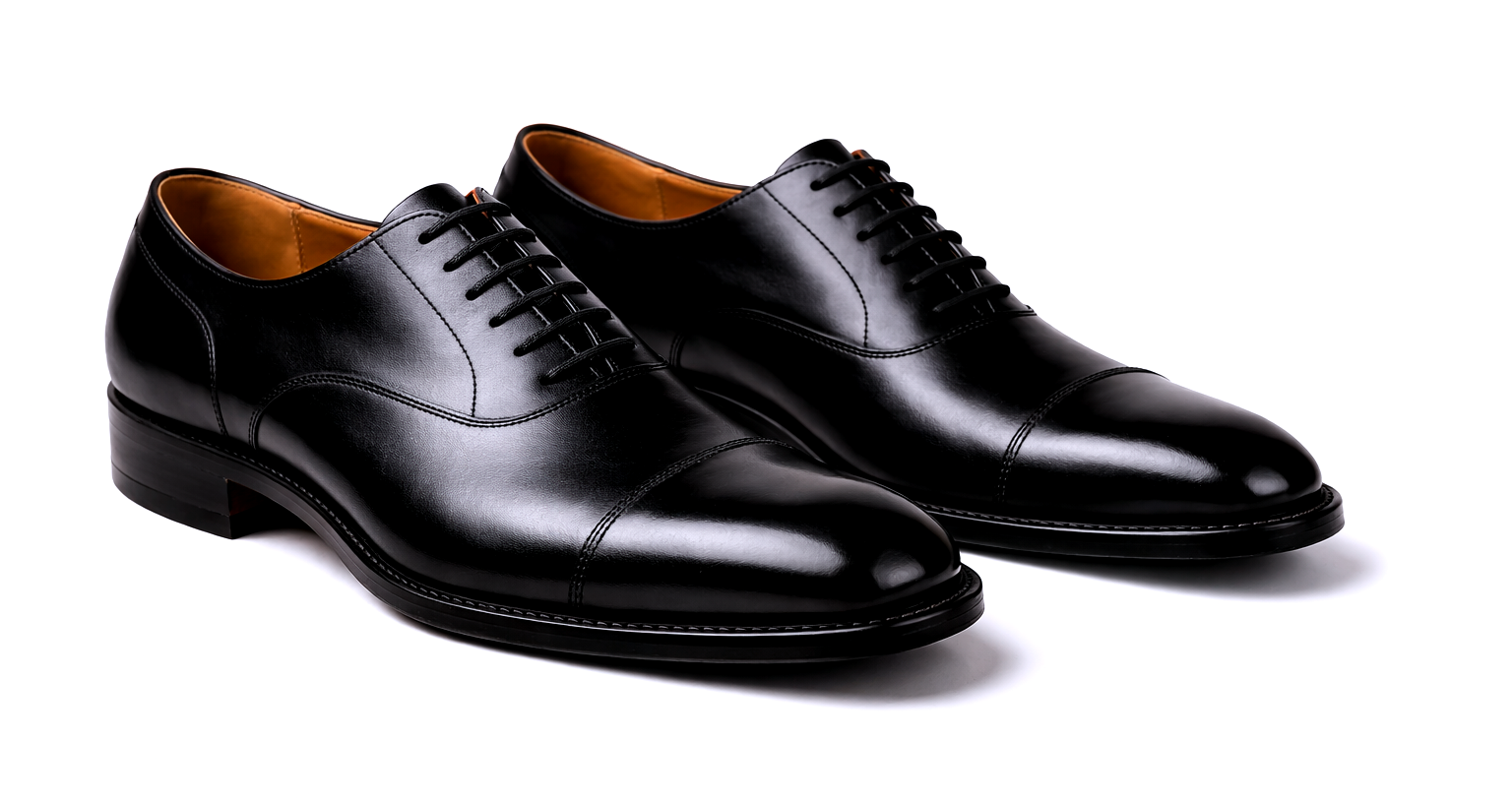 Paar schwarze Oxford-Schuhe aus Leder mit geschlossener Schnürung auf weißem Hintergrund